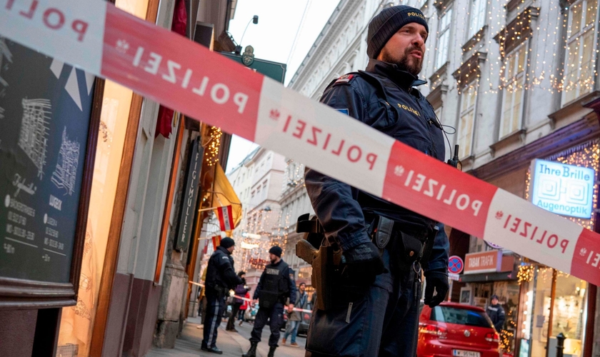 Policial austríaco permanece próximo a cordão de isolamento, em uma das cenas do ataque terrorista em Viena. (Foto: AFP)