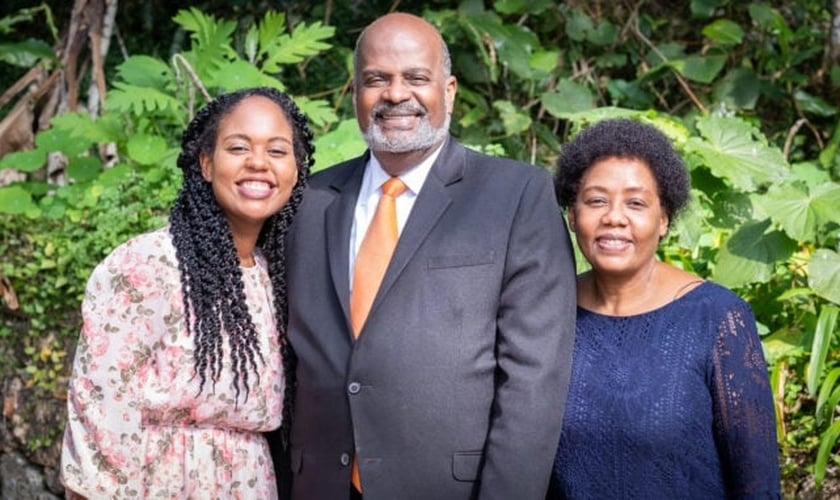 Pastor Eli Henry (ao centro), com sua esposa (à esquerda) e sua filha, Irma (à direita). (Foto: IASD News)