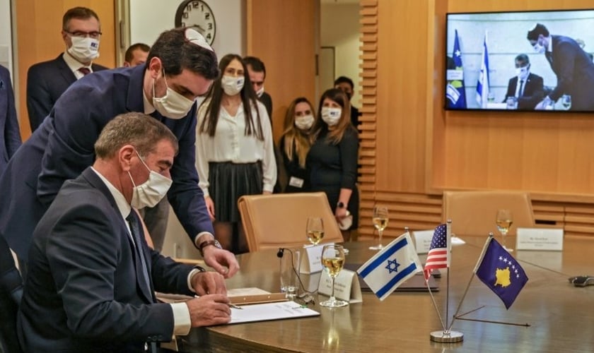 O ministro israelense das Relações Exteriores Gabi Ashkenazi assina documento de normalização das relações diplomáticas com Kosovo. (Foto: Reprodução / AFP)