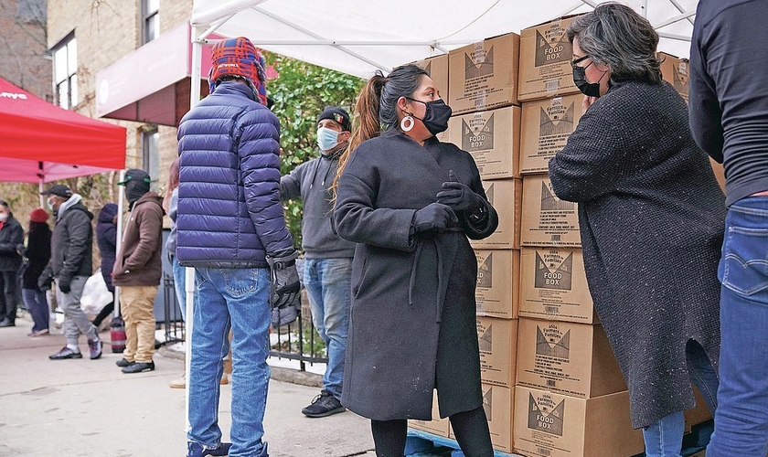 A voluntária Gloria Martinez, à esquerda, fala com Sofia Moncayo, que dirige um programa de distribuição de alimentos por meio da Mosaic West Queens Church. (Foto: Emily Leshner / AP)
