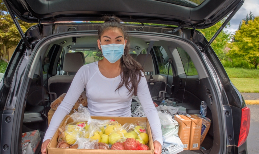 Diana Vergara possui uma caixa de alimentos frescos doada a sua família pela Visão Mundial na Igreja Adventista de Auburn City em Auburn, Washington. (Foto: Visão Mundial / Laura Reinhardt).