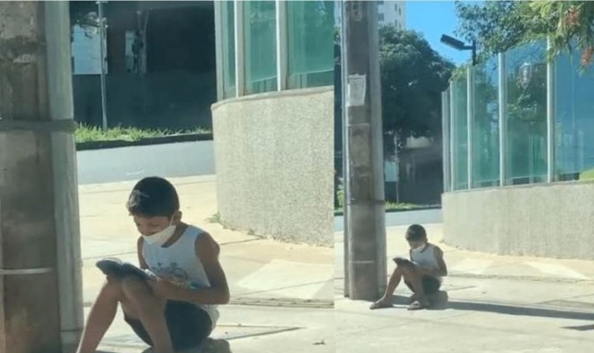 Nícolas lendo a Bíblia na calçada. (Foto: Reprodução / Instagram)