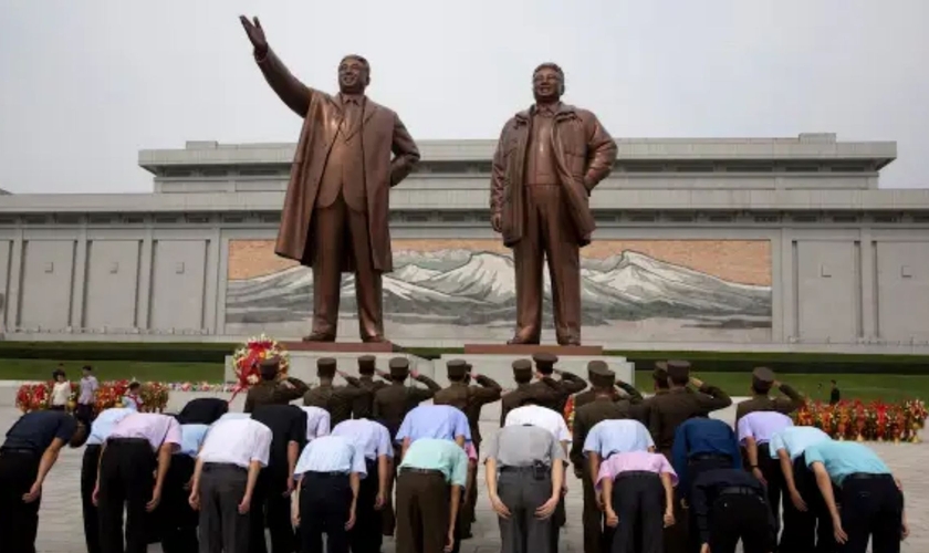 Cidadãos norte-coreanos são obrigados a reverenciar as estátuas dos líderes nacionais. (Foto: Ng Han Guan/AP)
