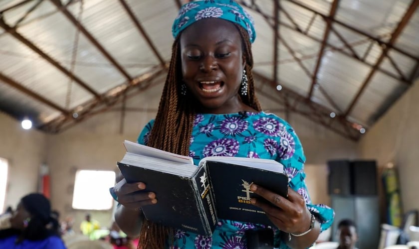 Mulher e a Bíblia Pidgin durante culto na Igreja do Cidadão Celestial em Lagos, Nigéria. (Foto: Reuters / Temilade Adelaja)