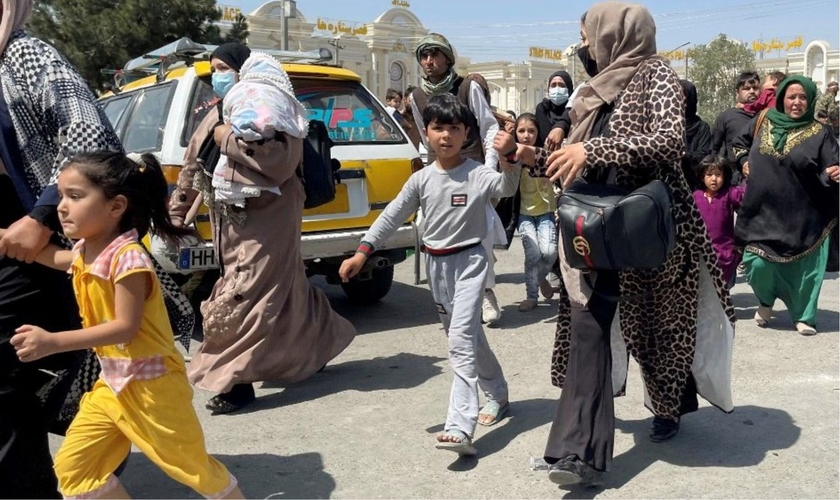 Mães e filhos tentam entrar no aeroporto Hamid Karzai, em Cabul, para fugir do país. (Foto: Reuters)