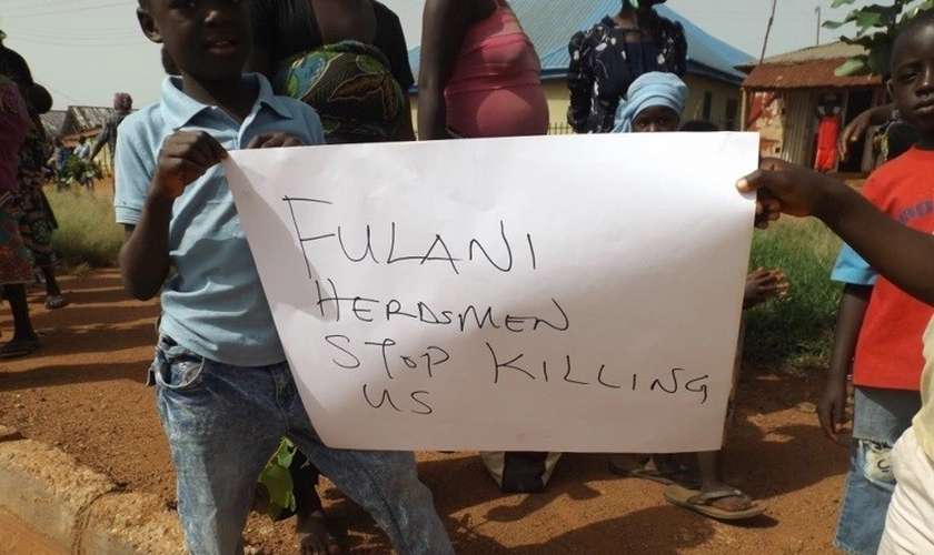 Nigerianos seguram uma placa pedindo o fim dos assassinatos. (Foto: Reprodução / ECCVN)