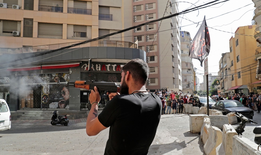 Um homem dispara sua arma no bairro de Tayuné durante os confrontos desta quinta-feira no Líbano. (Foto: Anwar Amro / AFP)