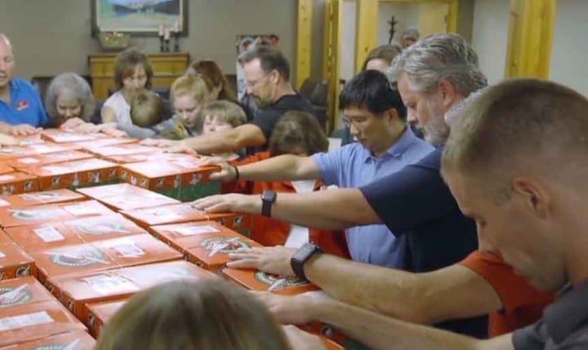 Voluntários da Operation Christmas Child oram pelas doações arrecadadas. (Foto: Reprodução / Instagram Operation Christmas Child UK)