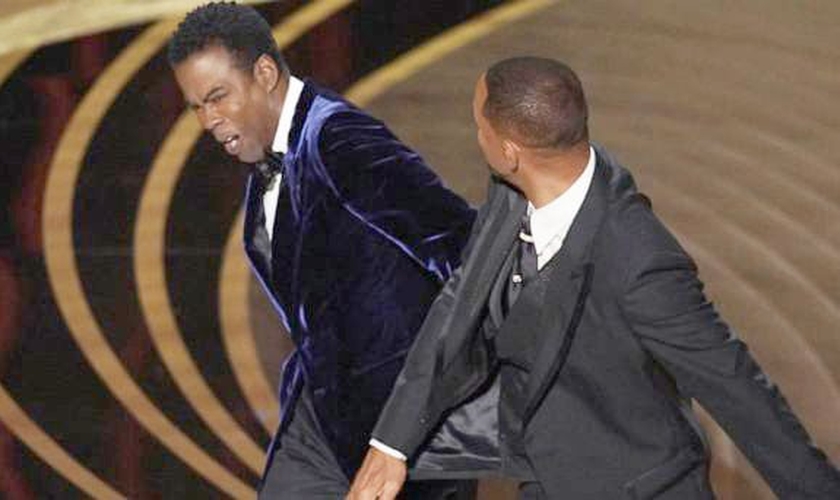 O ator Will Smith dá um tapa no rosto do comediante Chris Rock. (Foto: Reprodução/ABC News) 