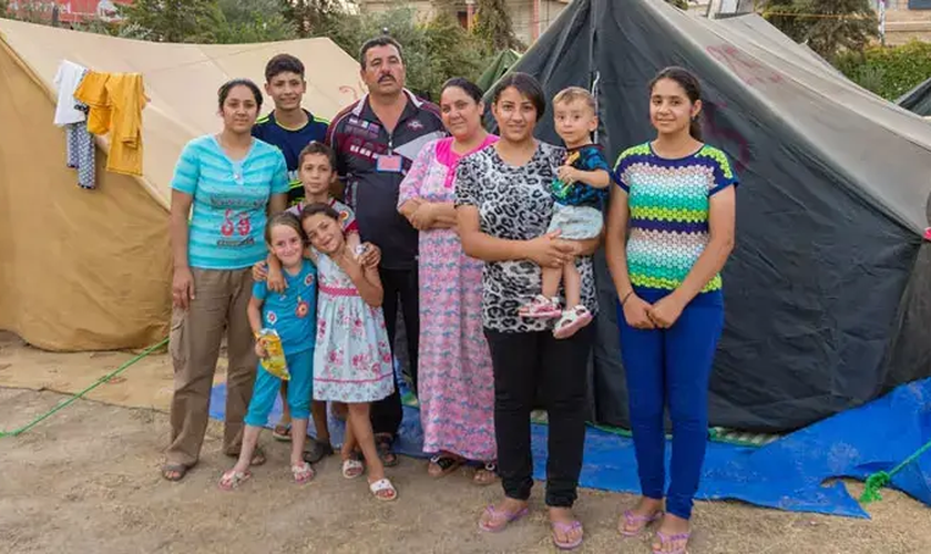 Família em frente a sua tenda após ter que fugir do Iraque por conta dos ataques do Estado Islâmico. (Foto: Portas Abertas)