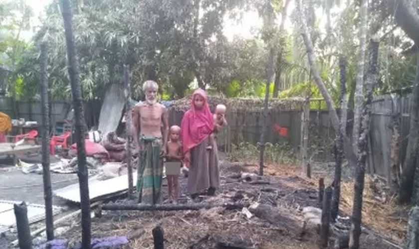 Família diante da casa incendiada. (Foto: Open Doors)