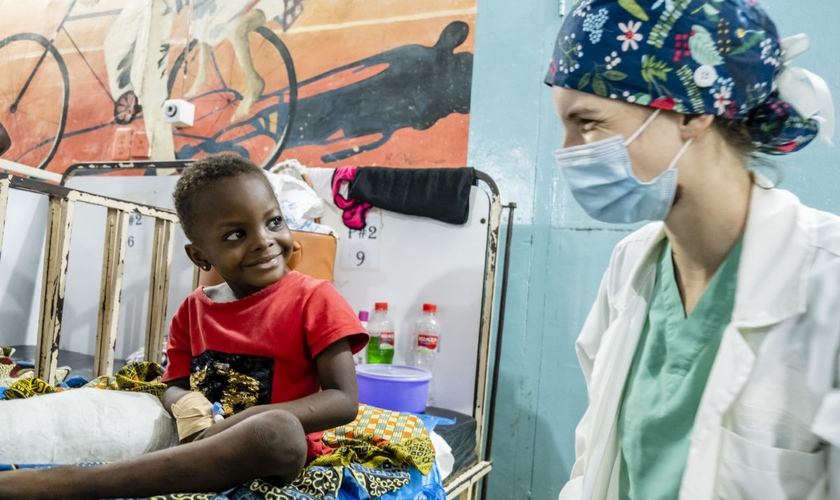 A voluntária médica Anna Leigh Breedlove brinca com uma criança na ala pediátrica do Baptist Medical Center de Nalerigu, Gana. (Foto: IMB).