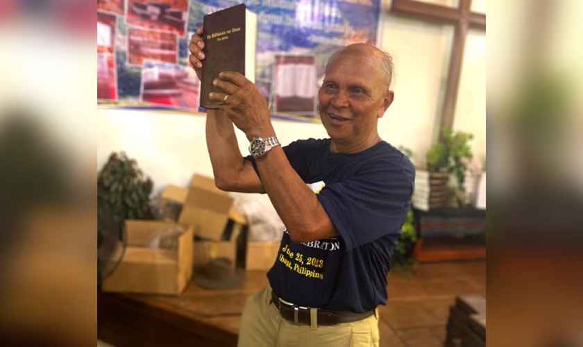 Nard Pugyao segurando a Bíblia no idioma Isnag. (Foto: Wycliffe Bible Translators)