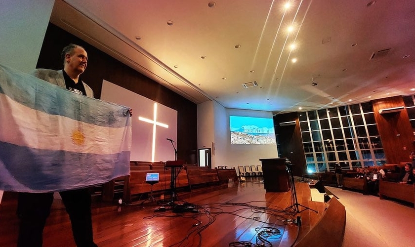 Líder cristão segura a bandeira argentina. (Foto: Facebook/Alianza Cristiana de Iglesias Evangélicas de la República Argentina)