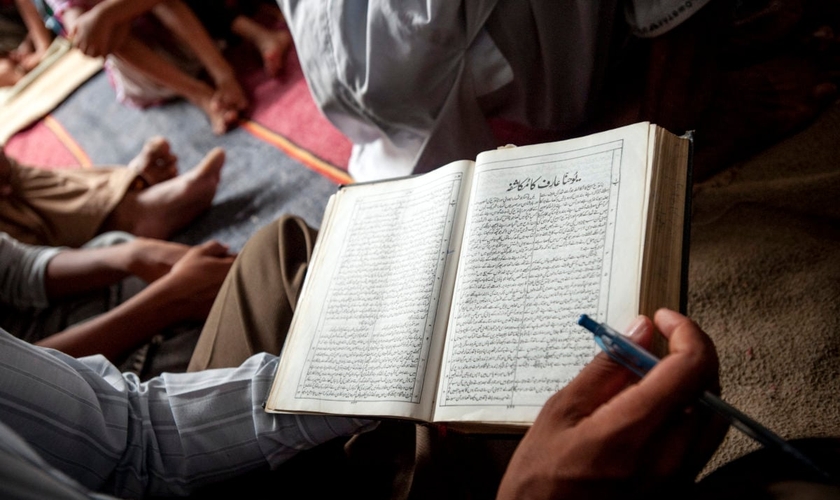 Um cristão paquistanês lê sua Bíblia durante um culto de domingo de manhã na igreja de uma comunidade ocupada. (Foto: IMB)