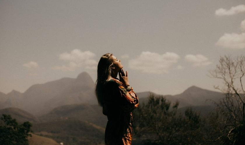 Mulher orando. (Foto: Reprodução/Unsplash/Marcos Paulo Prado)