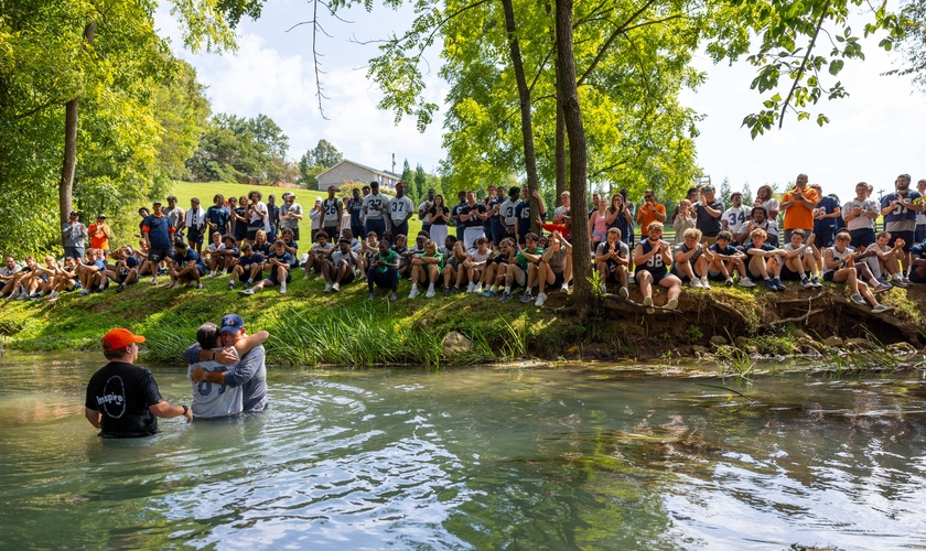 O batismo foi realizado em um riacho. (Foto: X/Carson-Newman University).