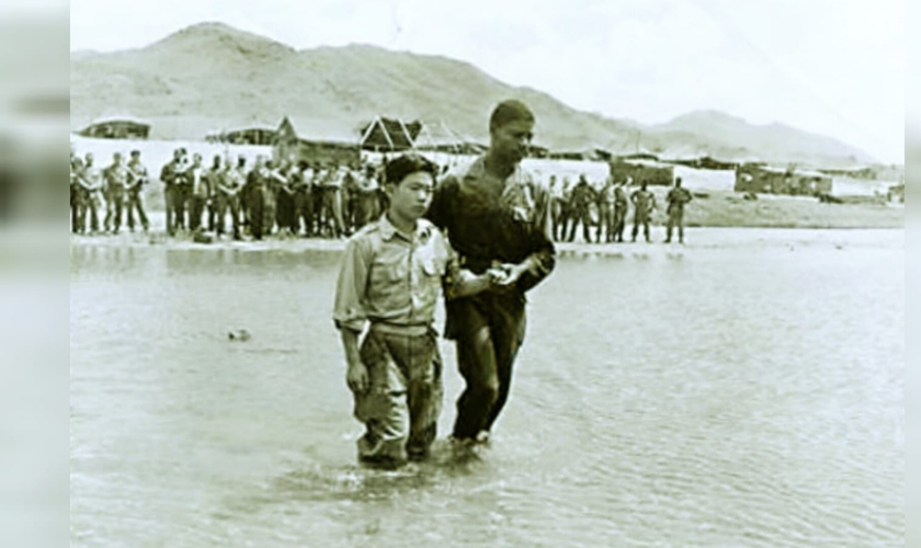 O soldado coreano Lee Hyeong-hwan é batizado pelo capelão Hubert Engram, perto de Seul, em 1952. (Foto: Instituto de História Militar).