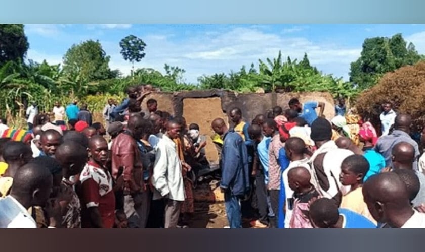 Moradores reunidos em frente à casa queimada do pastor Mukisa. (Foto: Morning Star News).