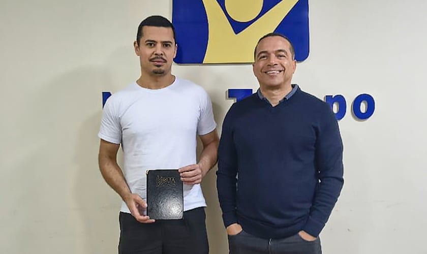 Jadesson e Willyan com a Bíblia perdida. (Foto: Reprodução/Notícias Adventistas)