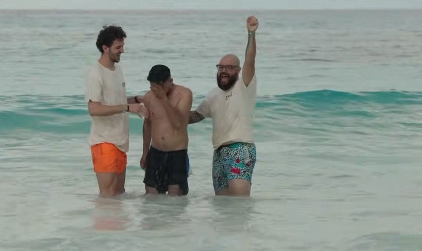 Jovem é batizado durante ação evangelística em praia de Cancún. (Captura de tela/YouTube/CBN News)