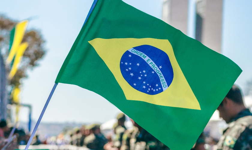 Bandeira do Brasil é erguida durante manifestação popular. (Foto: Pexels)