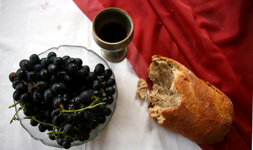 Mesa posta para Páscoa com o cálice, pão e uvas