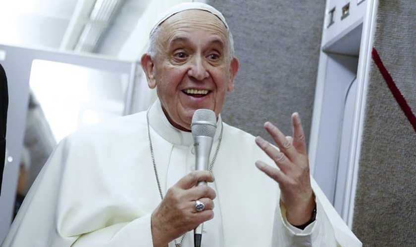 Papa Francisco fala dentro de avião durante sua viagem de volta para Roma. (Foto: Tony Gentile/Reuters)