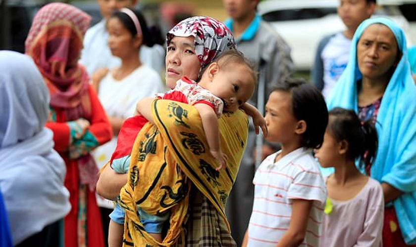 Mãe segura seu filho em meio ao caos instalado nas Filipinas, após cerco de terroristas. (Foto: Reuters)