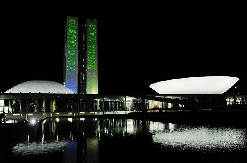 Torres do Congresso Nacional são iluminadas com a frase: “Holocausto nunca mais”